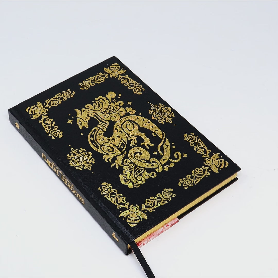 A black and gold book about dragons being opening and flipped through.